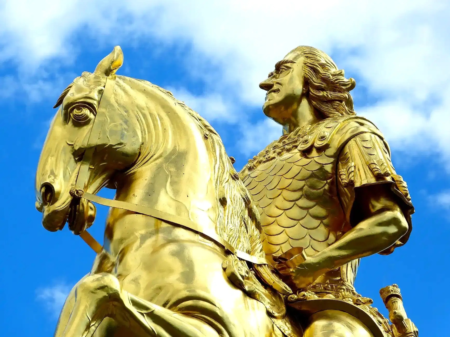 golden statue under blue skies during day time