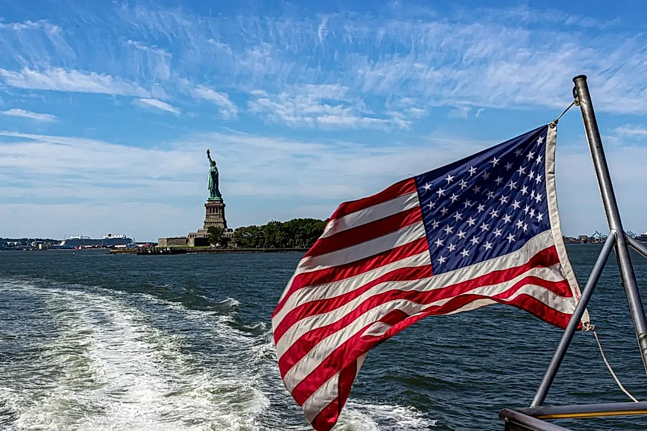 flag of usa and statue of liberty behind
